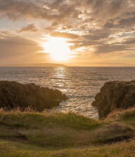 Looking across to the sea at the edge of a links course at sunset