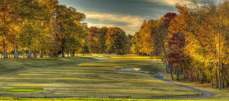 Golf course in autumn light with colourful trees lining the fairway