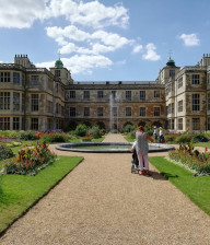 Lady walking through the flower gardens towards Audley End House in Essex