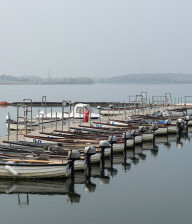 Rowing boats lined up at a jetty at Graham Water in Cambridgeshire