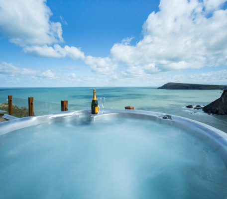 Hot tub with champagne bottle and glasses and sea views