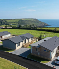 Aerial view of 4 holiday lodges at Seaview Gorran Haven with sea beyond