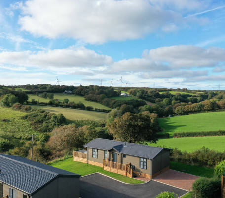 Aerial view of 2 lodges and surrounding countryside at Juliots Well Holiday Park, Cornwall