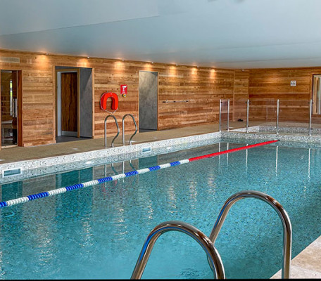 Indoor swimming pool in wood panelled room at Juliots Well Holiday Park, Cornwall