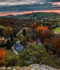 Autumnal leaf colours on trees with hills in background