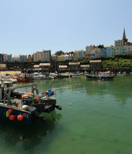Tenby harbour, green water and rows of pastel coloured houses on a hill